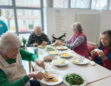 Senior*innen sitzen am gedeckten Tisch und genießen gemeinsam ein tunesisches Gericht.