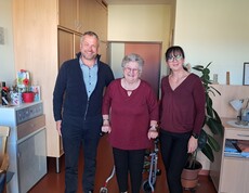 Bürgermeister Herr Tulnik und Pflegedienstleitung Frau Simko stehen gemeinsam mit Frau Krammer in ihrem Zimmer. Alle drei lächeln in die Kamera anlässlich ihres 90. Geburtstags.