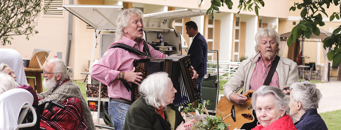 Musiker spielen für Bewohner*innen und Gäste beim Herbstfest im Garten des Caritas St. Hemma-Hauses.
