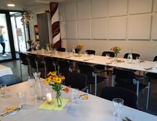 Langer Esstisch mit Besteck und Gläsern sowie Stühlen