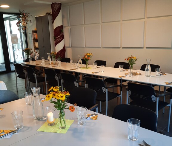 Langer Esstisch mit Besteck und Gläsern sowie Stühlen