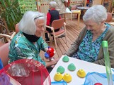 Zwei Bewohnerinnen eines Pflegewohnhauses sitzen an einem Tisch und beschäftigen sich im Rahmen einer Aktion zum Tag der Demenz mit bunten Spiel- und Bewegungsmaterialien.