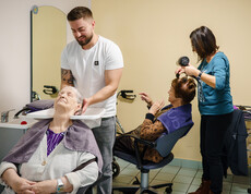 Zwei Seniorinnen erhalten Haarwäsche und Styling durch Friseurteam