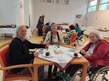 Bewohner*innen des Pflegewohnhauses St. Hemma Haus in Friesach beim Weihnachtsbasar, umgeben von festlicher Dekoration und Weihnachtsstimmung.