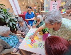 Mehrere Bewohnerinnen des Pflegewohnhauses nehmen gemeinsam an einer Aktivität zum Tag der Demenz teil und ordnen farbige Bildkarten zu, unterstützt durch Mitarbeitende.
