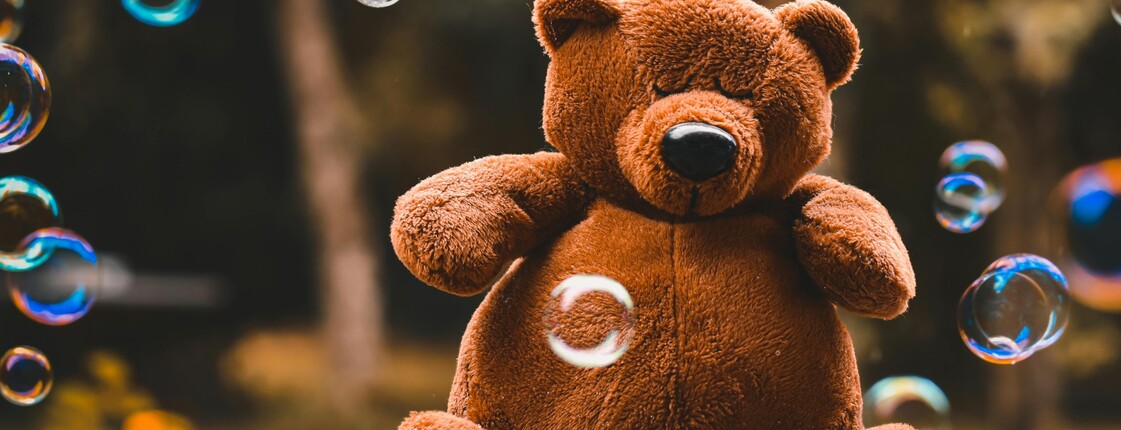 Teddybär sitzt in Seifenblasen