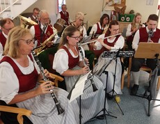 Die Marktmusikkapelle Lannach sitzt in Formation und spielt live im Pflegewohnhaus. Die Musiker tragen ihre traditionellen Uniformen.
