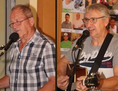 Zwei Männer singen gemeinsam am Mikrofon – einer spielt Gitarre, der andere begleitet am Keyboard. Im Hintergrund ist die Vorstellwand des Pflegepersonals aus dem Pflegewohnhaus zu sehen.