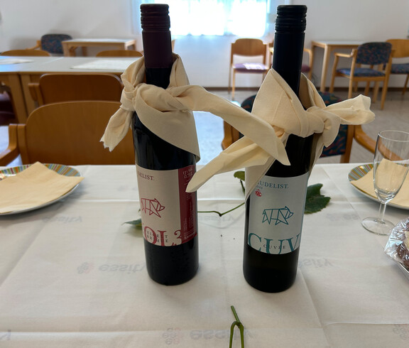 Zwei Weinflaschen stehen dekoriert auf einem festlich gedeckten Tisch im Haus Franziskus.