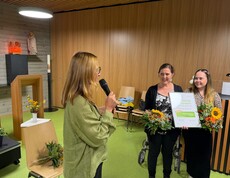 Bei der Verleihung des Gütesiegels „Mobilität im Alter“ präsentieren zwei Mitarbeiterinnen des Pflegewohnhauses Neumarkt gemeinsam mit einer Vertreterin von Styria vitalis die Auszeichnung und Blumensträuße.