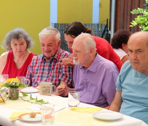 Bewohnerinnen, Bewohner und Gäste genießen gemeinsam das Jubiläumsfest zum 20-jährigen Bestehen des Pflegewohnhauses im festlich geschmückten Garten.