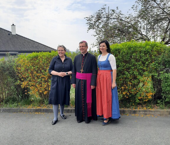 In der Mitte steht der Weihbischof, rechts von ihm die Hausleiterin und links von ihm die Pflegedienstleiterin vor dem Pflegewohnhaus.
