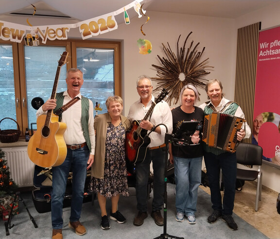 Musikgruppe mit Instrumenten feiert Bauernsilvester unter „New Year 2026“-Deko