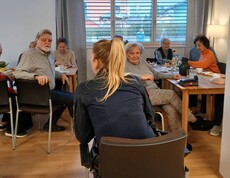 Ältere Menschen und eine Betreuering bei einem Vortrag