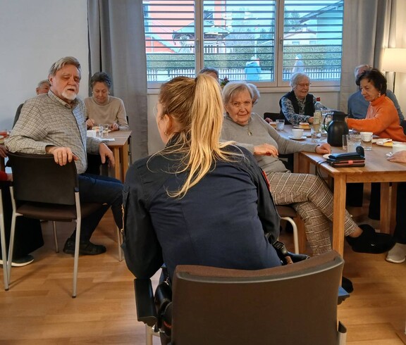 Ältere Menschen und eine Betreuering bei einem Vortrag
