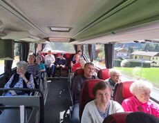 Senior*innen im Reisebus mit Panoramablick auf Berge und Landschaft