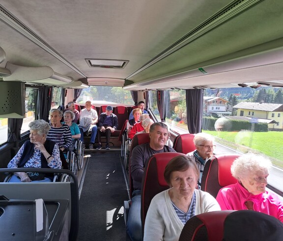 Senior*innen im Reisebus mit Panoramablick auf Berge und Landschaft