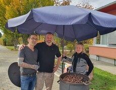 Hausleiter Josef Kurzmann steht gemeinsam mit den Maronibratern am Maroniofen.
