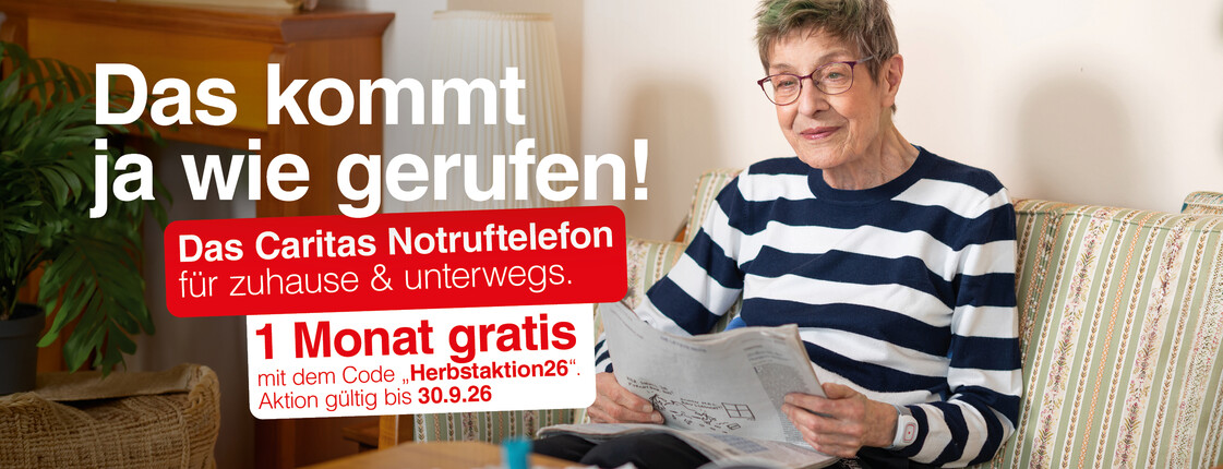 Ältere Person sitzt auf einem Sofa im Wohnzimmer und liest eine Zeitung. Links im Bild Werbetext: „Das kommt ja wie gerufen! Das Caritas Notruftelefon für zuhause & unterwegs. 1 Monat gratis! Aktion gültig bis 30.0.2026“.