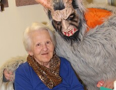 Krampus posiert neben einer Bewohnerin und beide schauen in die Kamera.
