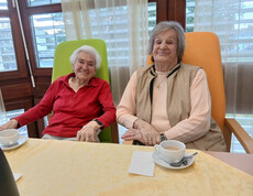 Zwei ältere Personen sitzen beim Kaffee gemeinsam an einem Tisch im Haus Magdalena.