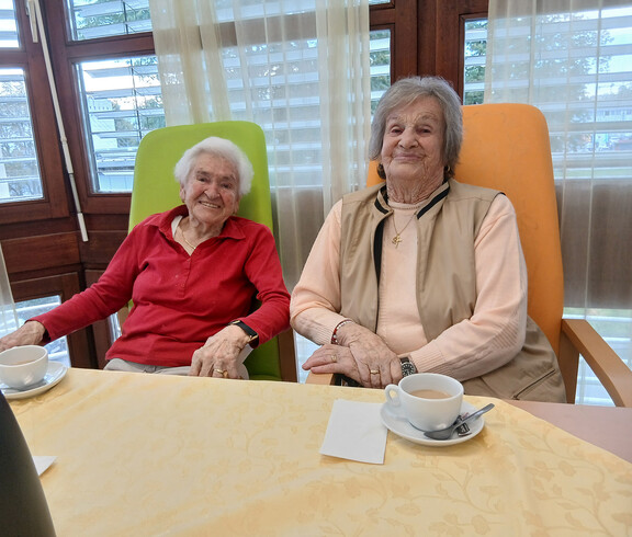 Zwei ältere Personen sitzen beim Kaffee gemeinsam an einem Tisch im Haus Magdalena.