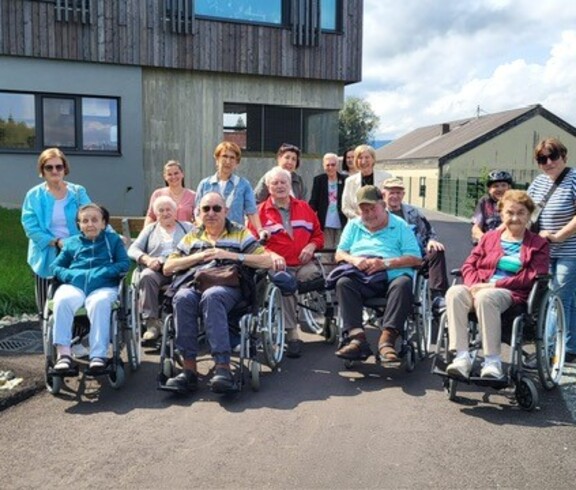 Bewohnerinnen und Bewohner des Pflegewohnhauses sitzen in Rollstühlen und machen sich gemeinsam mit Mitarbeiterinnen und Angehörigen auf den Weg zum Generationenfest der Marktgemeinde Wies.