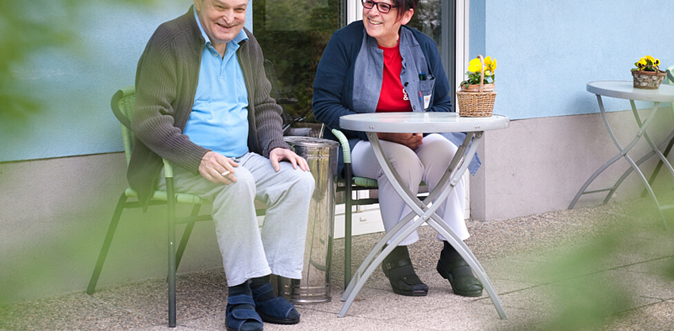 Ein Mann und eine Frau sitzen im Garten