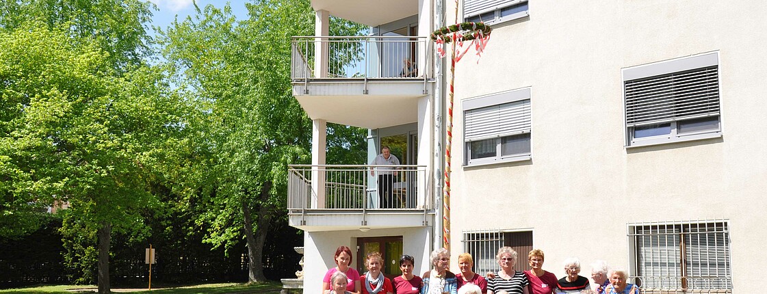 Gruppenfoto unserer BewohnerInnen und MitarbeiterInnen vom Caritas Haus Elisabeth in Rechnitz vor dem Maibaum