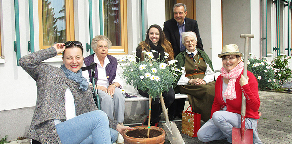 Freiwillige Helfer aus dem Büro X mit Bewohnerinnen im Garten des Haus St. Klemens