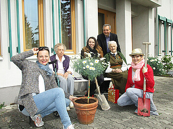 Freiwillige Helfer aus dem Büro X mit Bewohnerinnen im Garten des Haus St. Klemens