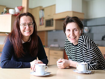 Zwei Frauen sitzten an einem Tisch bei einer Tasse Kaffee.