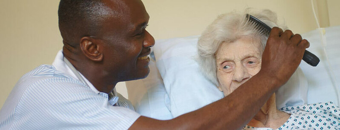 Pfleger kämmt ältere Dame